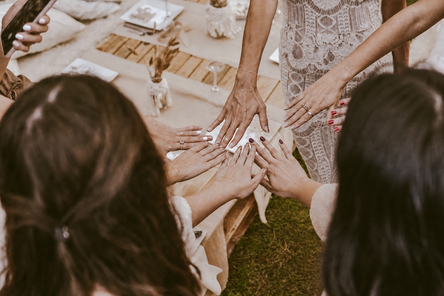 Friends showing their EverLink permanent bracelets at a bridal celebration
